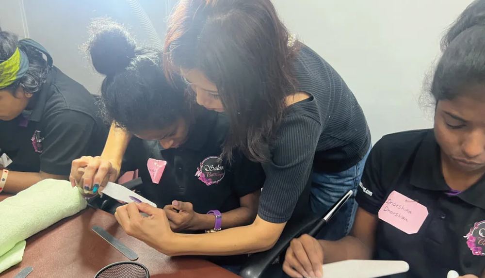 A trainer guiding a student's hand through a filing technique